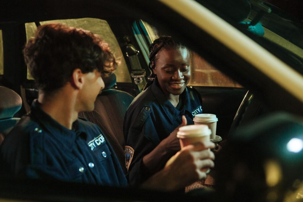 Dos policías amigos tomando café en un auto